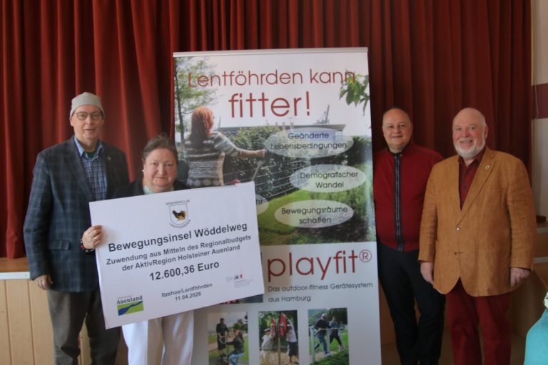 Übergabe Fördermittel-Scheck Vier Personen präsentieren einen Fördermittel-Scheck vor einem Banner