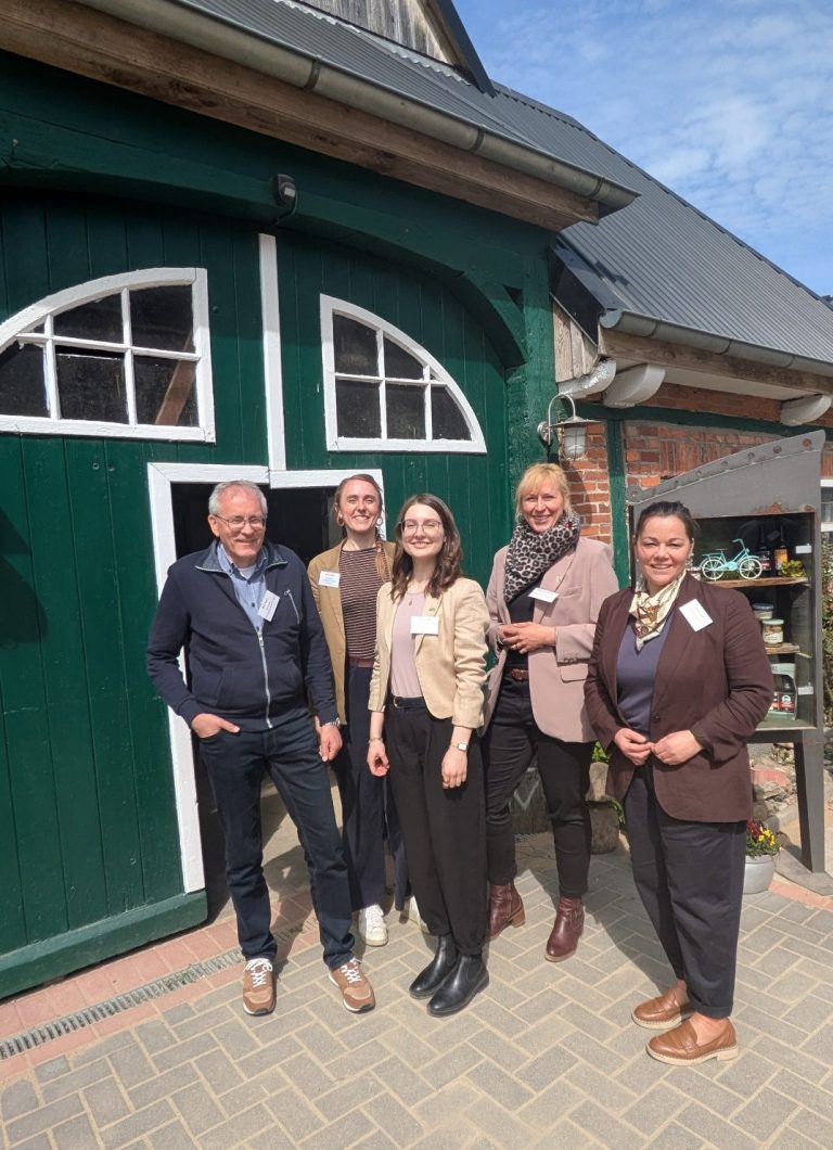 Vertreter:innen der AktivRegionen Pinneberger Marsch&Geest, Holsteiner Auenland, Steinburg Fünf Menschen posieren vor einem grünen Eingang eines Gebäudes im Freien.