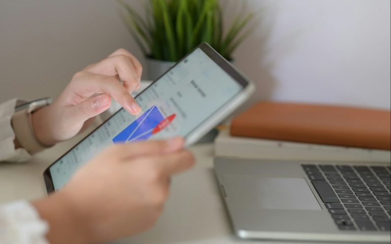 Papierflieger als Symbol für Neuigkeiten Ein orangefarbener Papierflieger mit einer E-Mail-Benachrichtigung und Wolken.